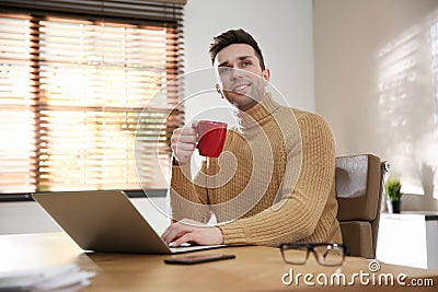 Young man with cup of drink relaxing Stock Photo