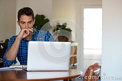 Young man deep in thought while working remotely from home Stock Photo