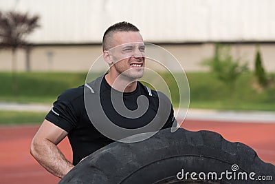 Young Man Doing Tire Workout Outdoor Stock Photo