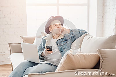 Young man dreams startup business, works home in living room with laptop. Chatting with friends via online chat rooms Stock Photo