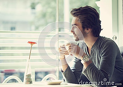 Young man drinking coffee in cafe Stock Photo