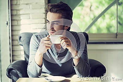 Young man drinking coffee in cafe Stock Photo