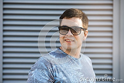 A young man drinks coffee in the city and walks outside Stock Photo