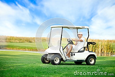 Young man driving golf buggy Stock Photo