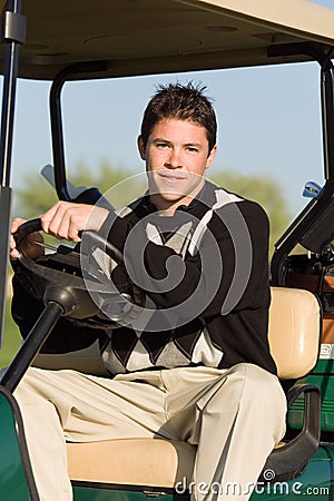 Young Man Driving Golf Cart Stock Photo