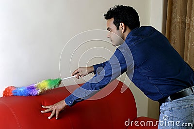 Young man dusting home Stock Photo