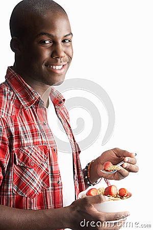 Young Man Eating Bowl Of Cereal In Studio Stock Photo