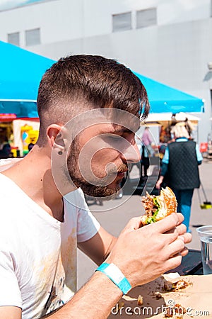 A young man eating a burger Stock Photo