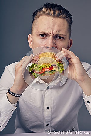 Young man eating a fresh burger Stock Photo