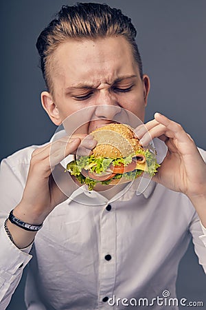 Young man eating a fresh burger Stock Photo