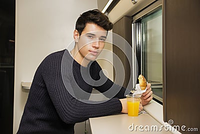 Young man eating refreshments on a train Stock Photo