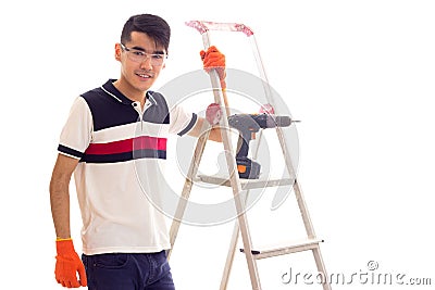 Young man with electric screwdriver and ledder Stock Photo