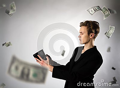 Young man and empty wallet. Currency, expense and income concept. Dollars Stock Photo