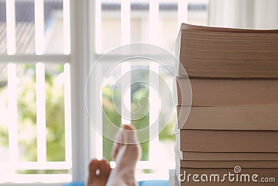 Young man enjoying books near a window. Pleasure of reading books. Relax and holidays. Stock Photo