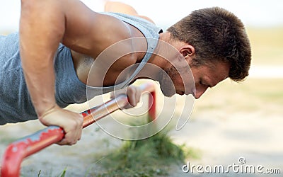 Young man exercising on horizontal bar outdoors Stock Photo