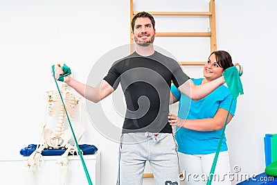 Young man exercising with resistance band in physical therapy Stock Photo