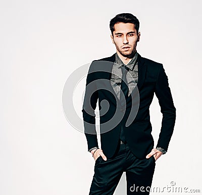 A young man in a fashionable suit posing. Indoor. Warm color. Stock Photo