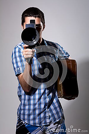 Young man filmmaker with old movie camera and a suitcase in his Stock Photo