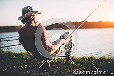 Young man fishing at pond and enjoying hobby Stock Photo