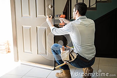 Young man fixing a door lock Stock Photo