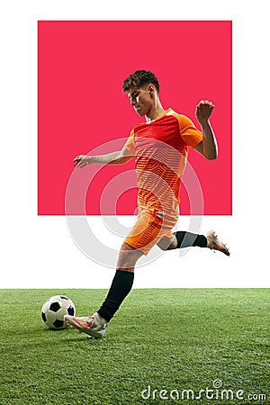 Young man, football athlete in motion, dribbling ball over white background with grass flooring. Poster Stock Photo