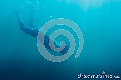 Young man free diver swimming in deep sea. Stock Photo