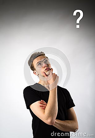 Young man is full of doubts and hesitation. Young man and Question mark Stock Photo