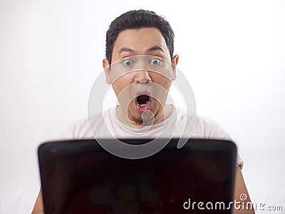 Young Man Gasping, Shocked Expression Looking at Laptop Stock Photo