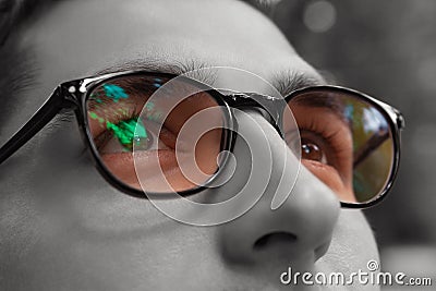 Young man gets colorful bright sight wearing glasses. Eyewear to improve vision. Close up of eyes Stock Photo