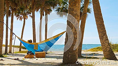 Young man and girl in hammock in beautiful beach Stock Photo