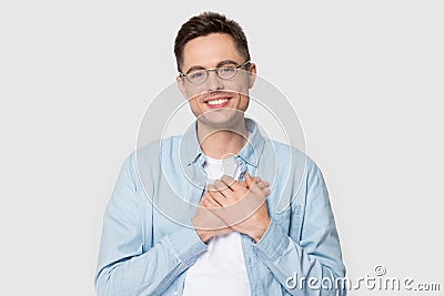 Young man in glasses holds hands on chest feels gratitude Stock Photo