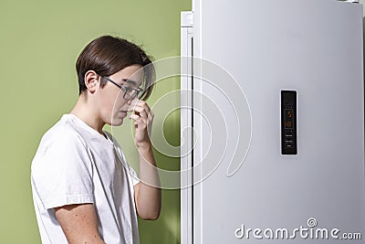 Man feeling bad smell from fridge in kitchen Stock Photo