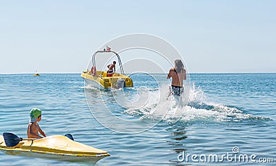 Young man glides on water skiing on the waves on the sea, ocean. Healthy lifestyle. Positive human emotions, feelings, joy. Stock Photo