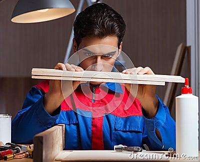 Young man gluing wood pieces together in DIY concept Stock Photo