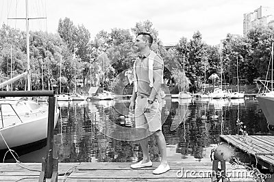 Young man goes to his yacht in the river bay. Successful guy in sea bay with yacht. Summertime for sailing of young men Stock Photo