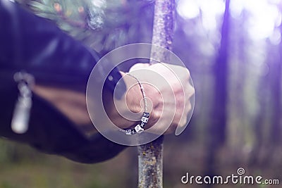 A young man goes through the woods leaning on a stick. The concept of a difficult road, a private road. Stock Photo