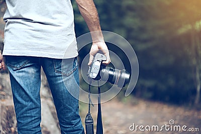 Man hand camera in forest background Stock Photo