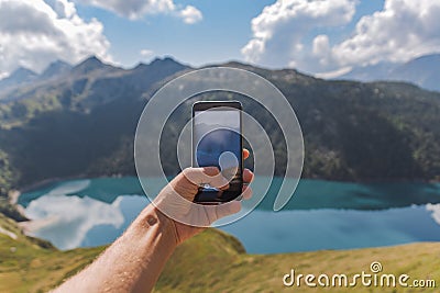 Young man hand holding a smartphone and take a picture of an astonishing panorama Stock Photo