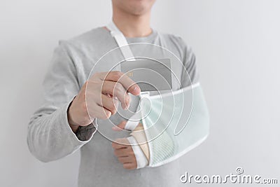 Young man with hand injured wearing splint, broken arm, showing empty blank card Stock Photo
