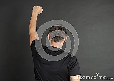 Young man with hand raised up protest gesture back pose Stock Photo