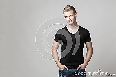 Young man with hands in pockets isolated on gray background Stock Photo