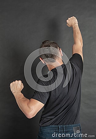 Young man with hands raised up protest gesture back pose Stock Photo