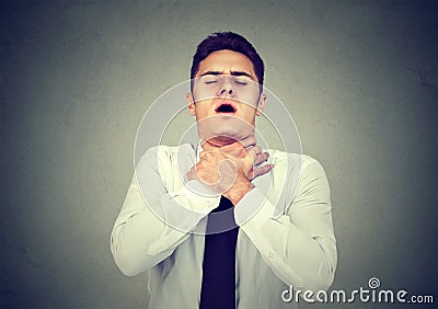 Young man having asthma attack or choking can`t breath suffering from respiration problems Stock Photo