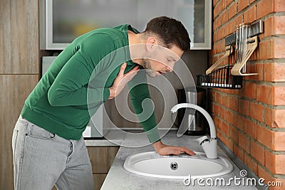 Young man having nausea in kitchen Stock Photo