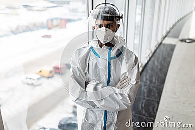 Young man in Hazmat protective suits look glass at home or office during outbreak of Coronavirus, Covid-19 Stock Photo