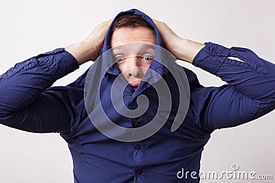 Young man hiding in a blue shirt hiding his face Stock Photo