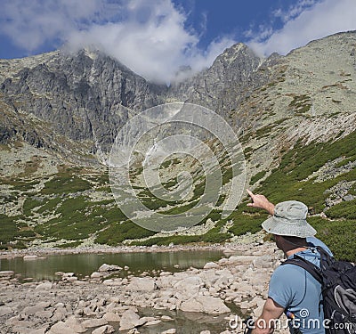 Young man hiker looking and point to mountain Peak Lomnicky stit 2 634 m at Summer, the highest mountain peaks in the Editorial Stock Photo