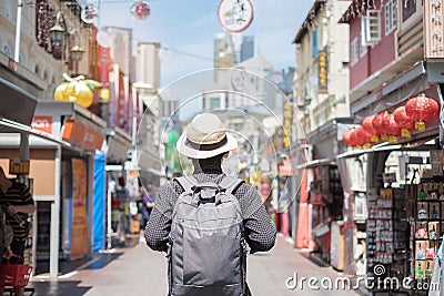 Young man hipster traveling with backpack and hat, happy Solo traveler walking at Chinatown street market in Singapore. landmark Stock Photo