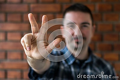 Young man in his 30s showing three fingers. Selective focus Stock Photo