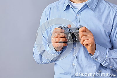 Young man holding a camera , isolated on gray background Stock Photo